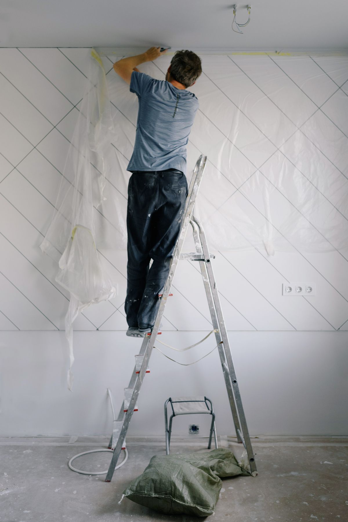 Drywall patch being skim-coated and feathered smooth on an interior wall before priming